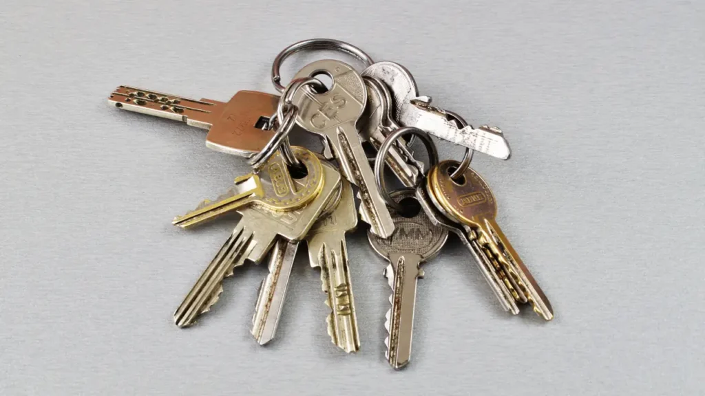 A large, disorganized cluster of silver and brass door keys on a key ring.