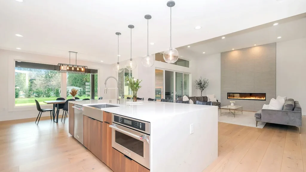 Bright modern open concept kitchen and living room illuminated by smart ceiling lights.