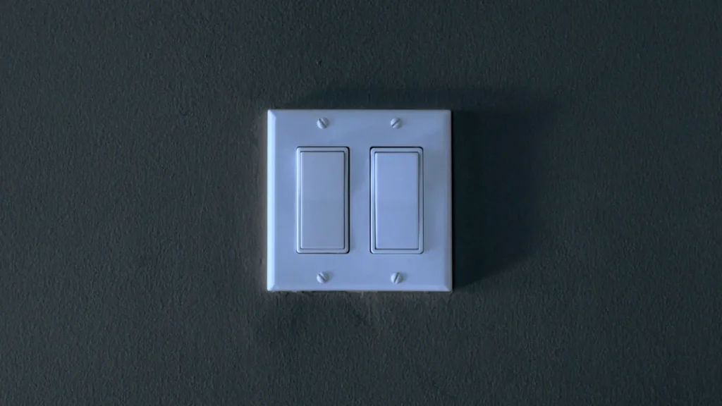 Two standard white physical wall light switches turned to the on position.