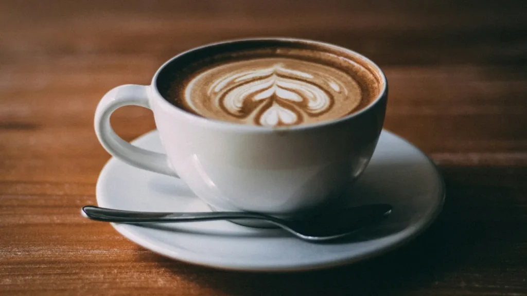 Cup of coffee with latte art on a wooden table.