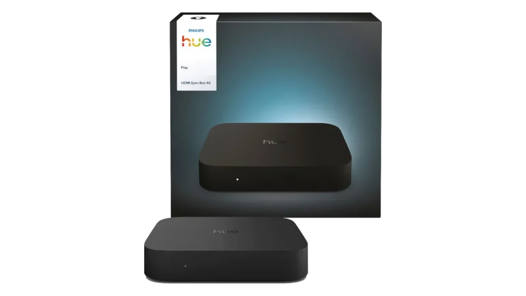 Retail packaging for the Philips Hue Play HDMI Sync Box 4K with a standalone unit in the foreground on a clean grey background.