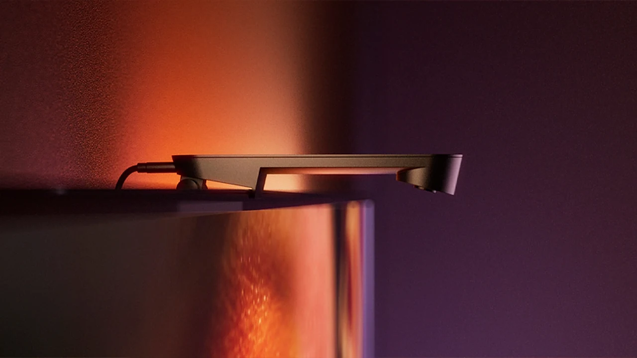 Hue Play Screen Sync camera clipped to the top edge of a TV with warm light on the wall